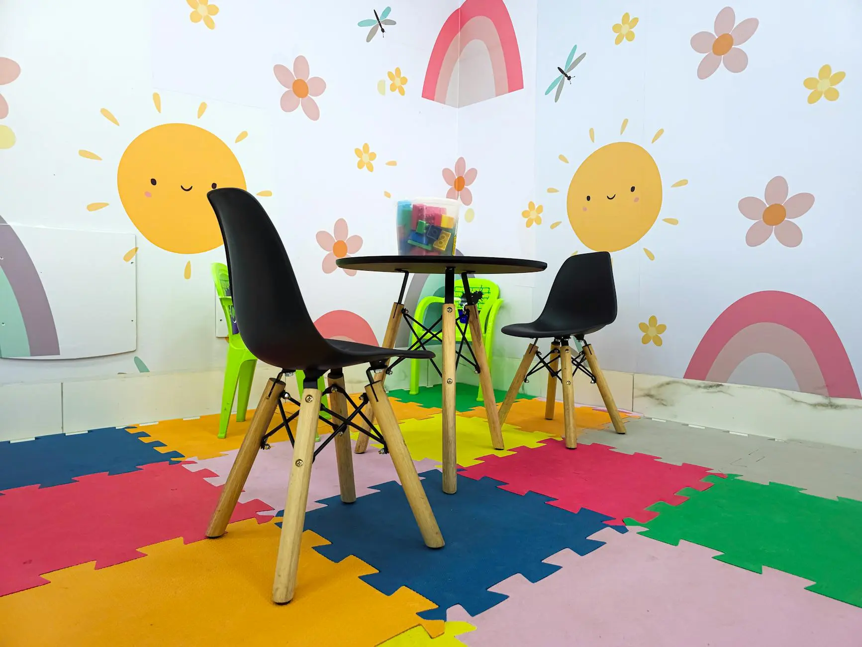 Vibrant children's playroom featuring playful sun and rainbow wall art with colorful mats.