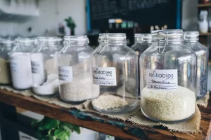 Glass jars in an eco-friendly refill shop filled with organic grains and items on display.