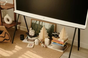Warm and cozy living room corner featuring holiday decor, books, and art for a festive atmosphere.