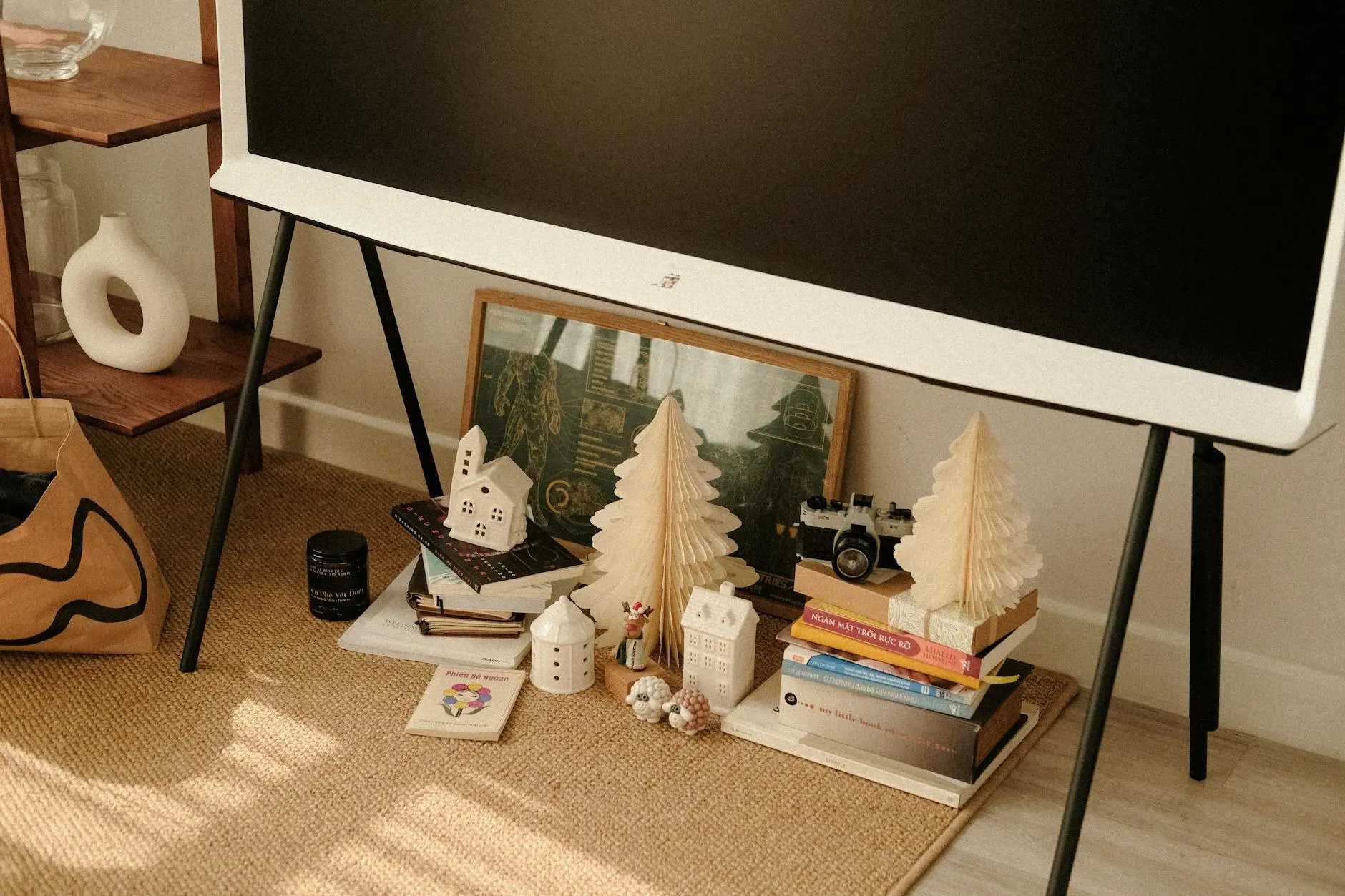 Warm and cozy living room corner featuring holiday decor, books, and art for a festive atmosphere.